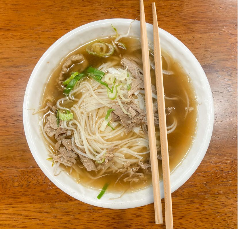 고기 고명과 파가 올려진 따뜻한 쌀국수 한 그릇