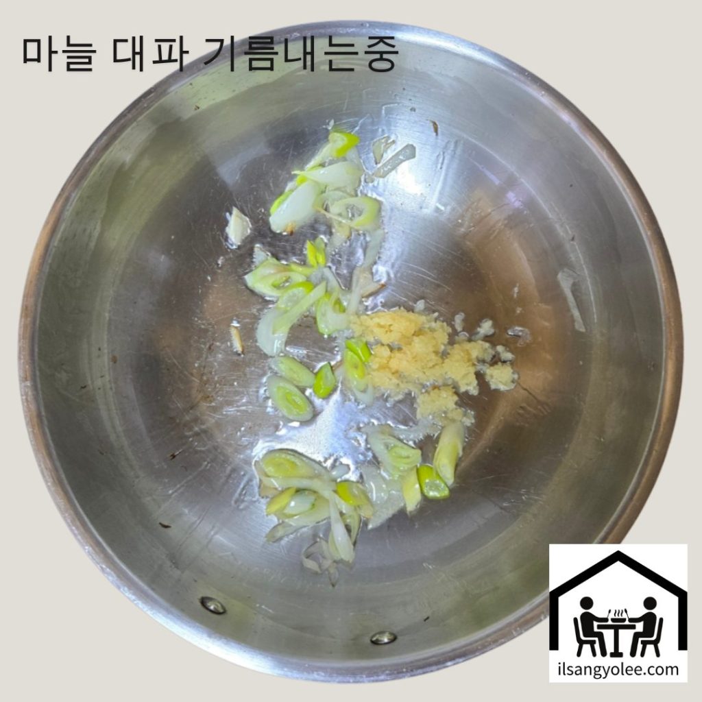 냄비에 식용유를 두르고 대파와 다진 마늘을 볶는 모습