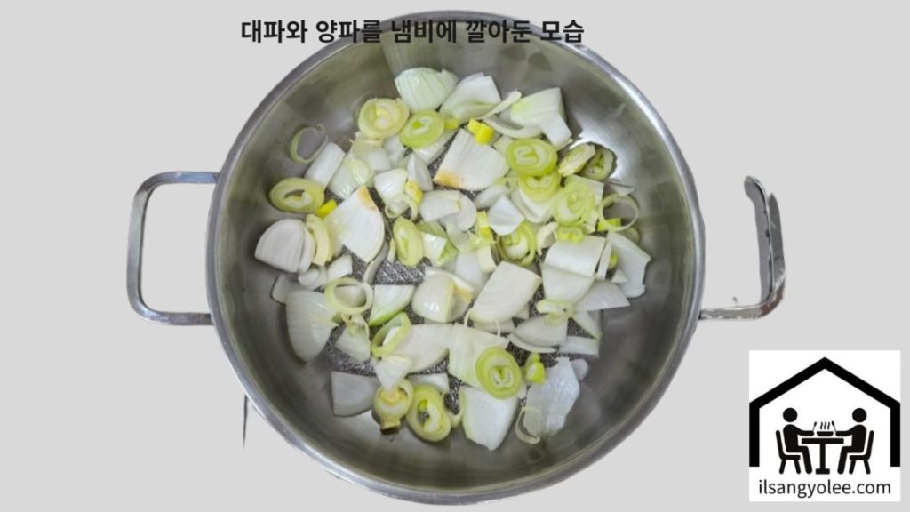 냄비 바닥에 깔아놓은 양파와 대파. 김치찜의 채소 베이스 준비 과정