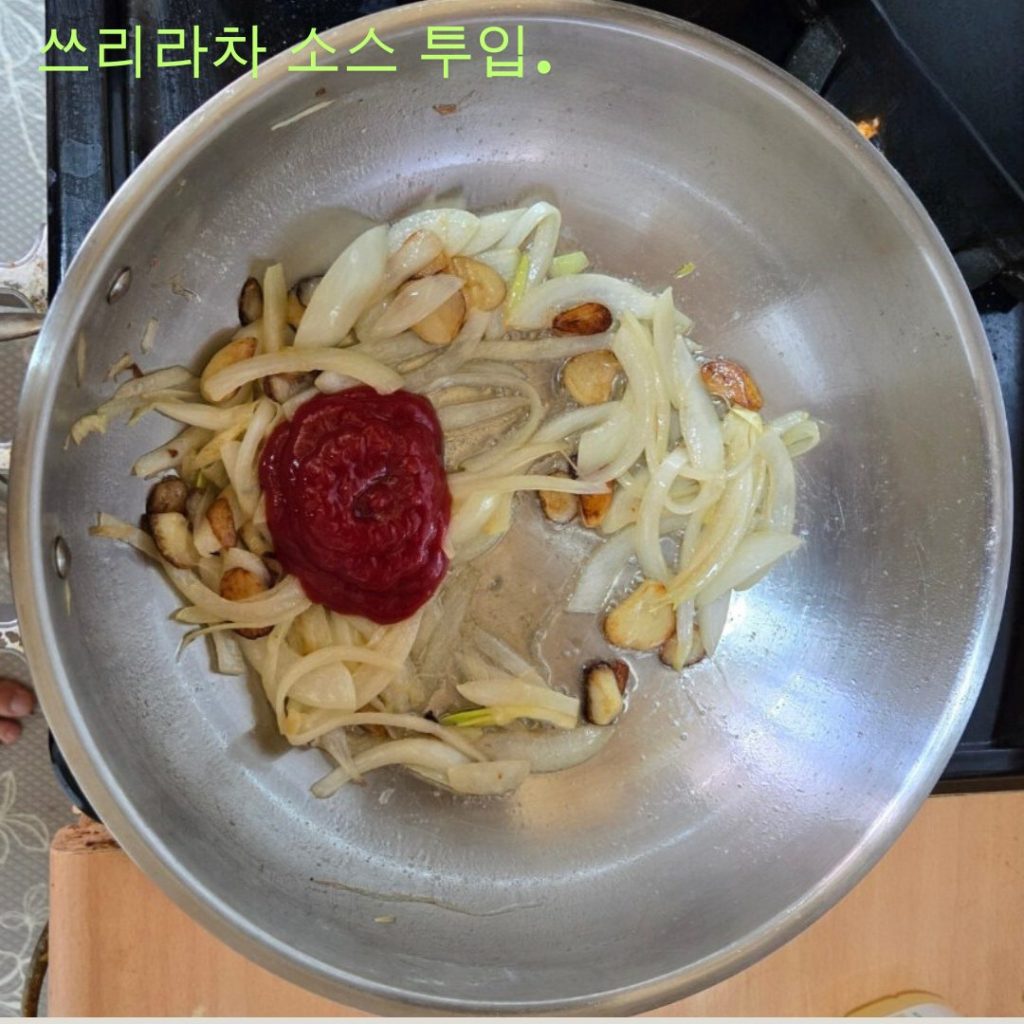 볶아진 양파와 마늘에 버터, 케첩, 스리라차를 넣는 모습