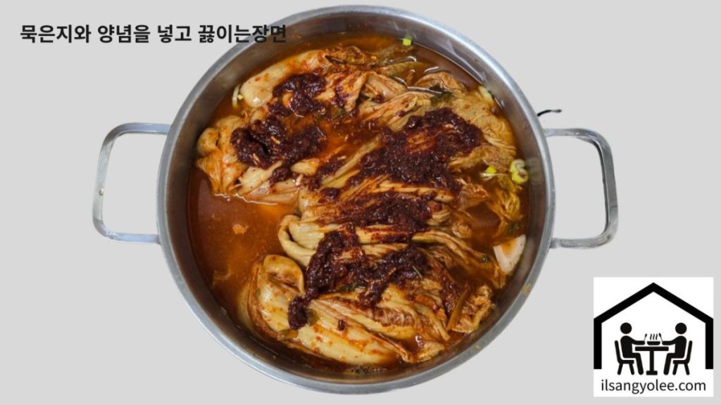  양파와 대파 위에 통째로 올린 묵은지와 양념장, 그리고 육수를 붓는 장면