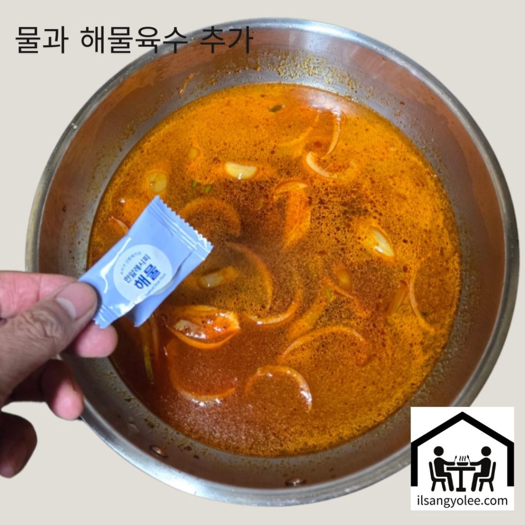 볶은 재료에 육수를 붓고 해물 동전육수를 넣는 장면