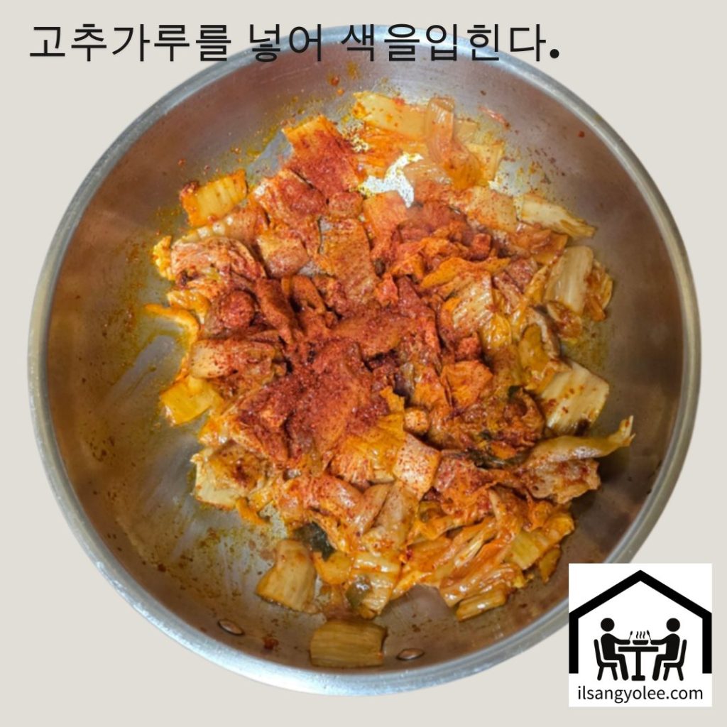 묵은지와 돼지고기가 볶아진 팬에 고춧가루를 뿌리는 모습