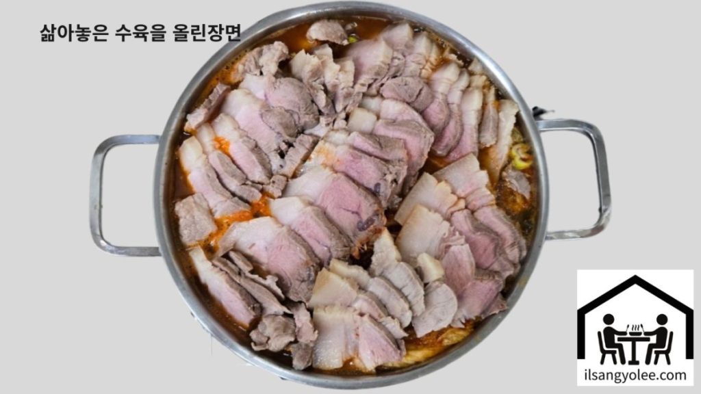 잘 삶아 썰어놓은 돼지고기를 묵은지 위에 다시 얹어 익히는 최종 단계