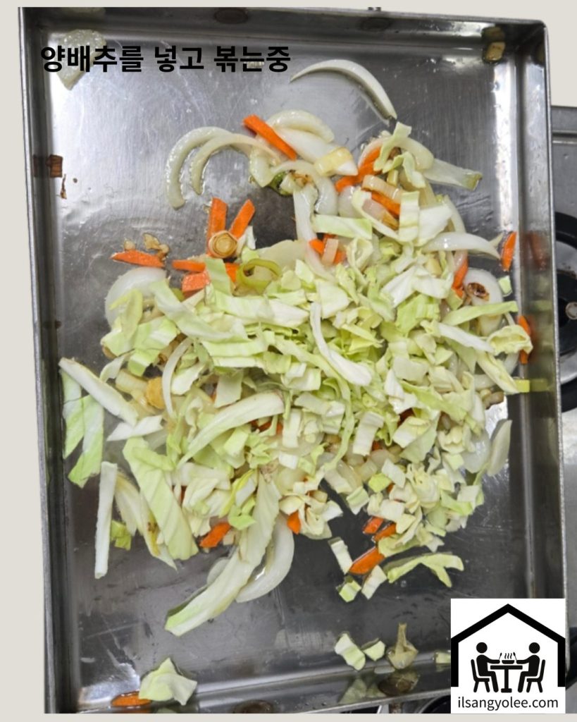 양배추가 추가되어 다른 채소와 함께 센 불에서 볶아지는 모습