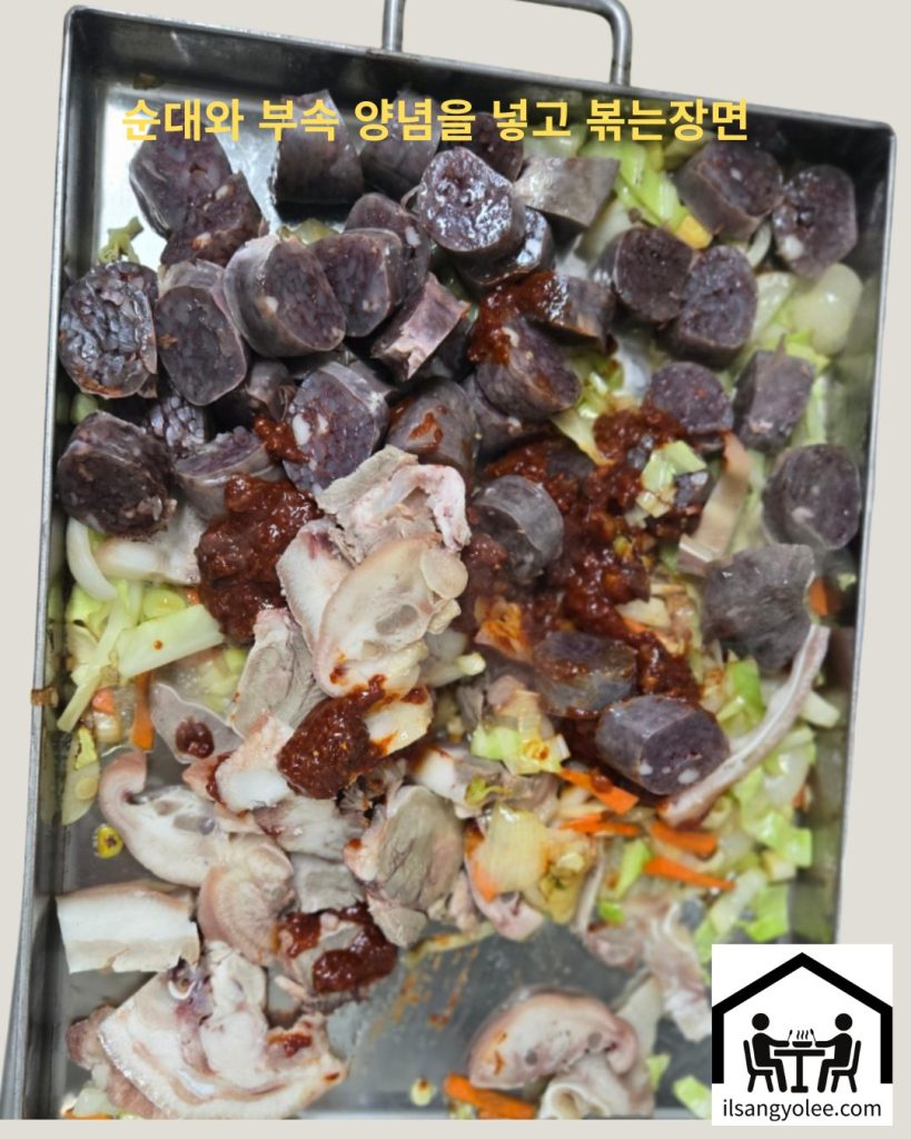 양념과 함께 철판에서 맛있게 볶아지고 있는 순대와 부속, 채소