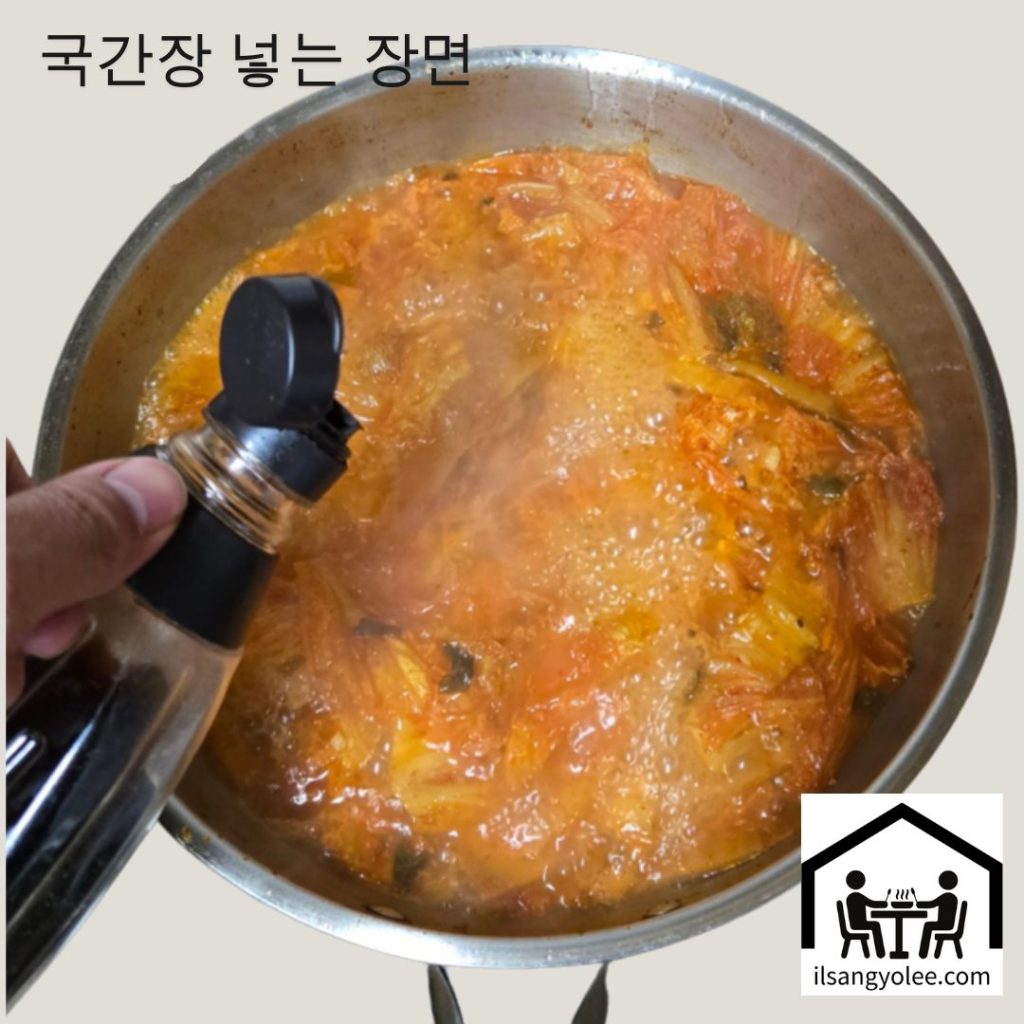 끓어오르는 김치찌개에 국간장을 넣어 간을 맞추는 모습