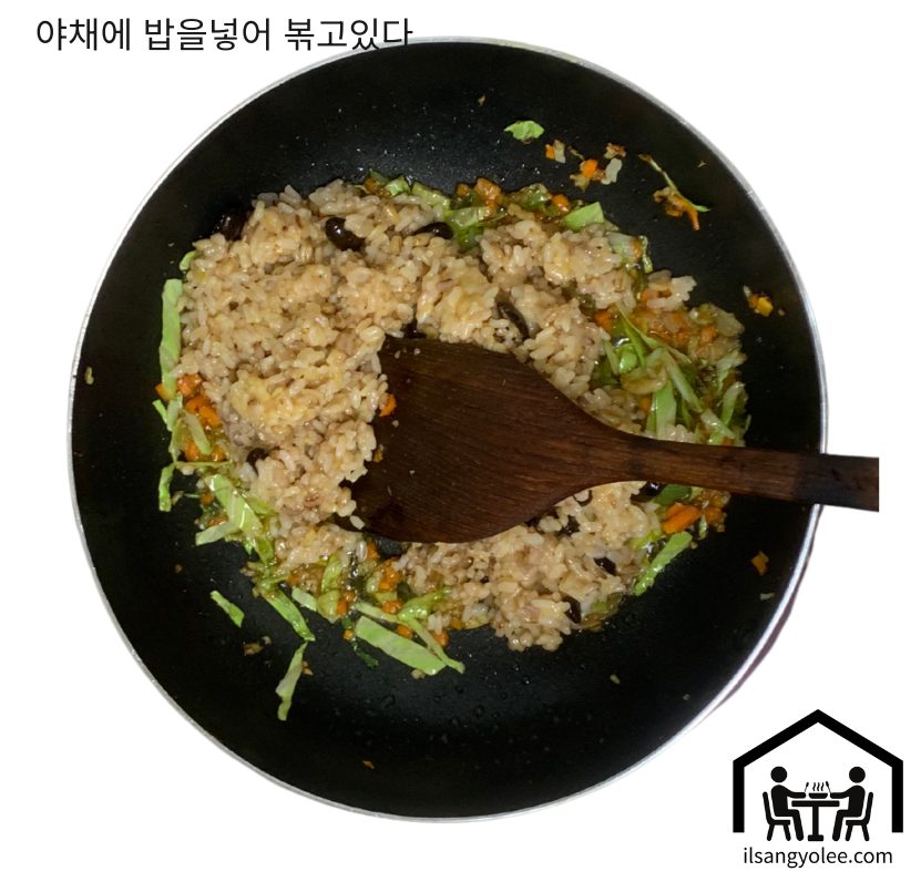 팬에 밥과 채소를 함께 볶으며 밥알을 분리하는 모습