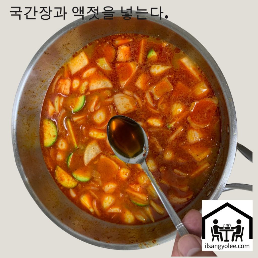 고추장찌개에 스푼을 이용해 국간장을 넣고있는모습.  
